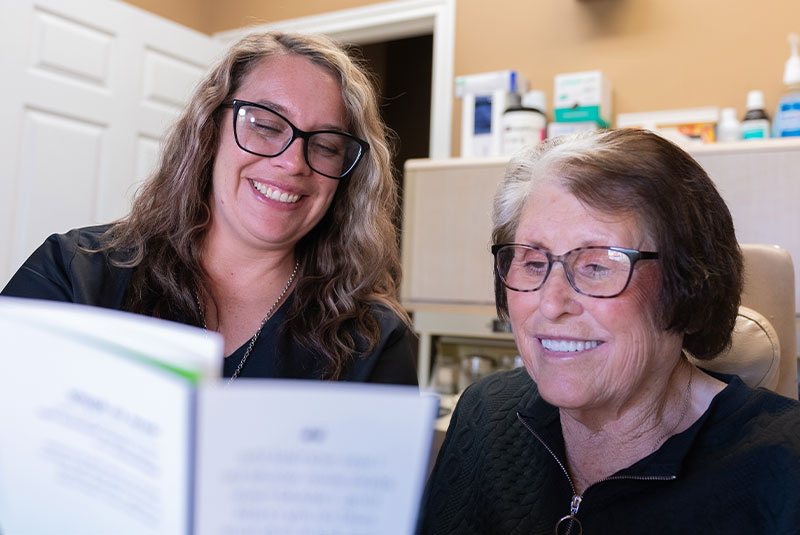 coordinator with lady looking at pamphlet