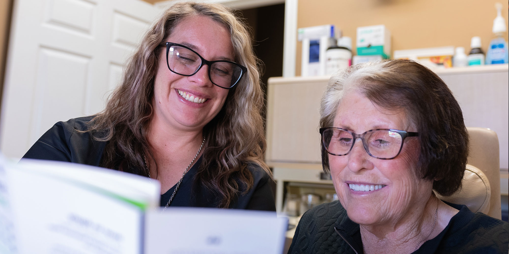 lady with dark and grey hair read insurance and financing pamphlet