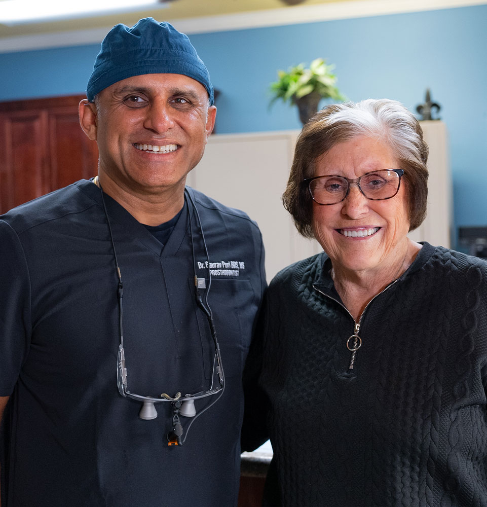 dr puri with lady and her new full arch dental implants